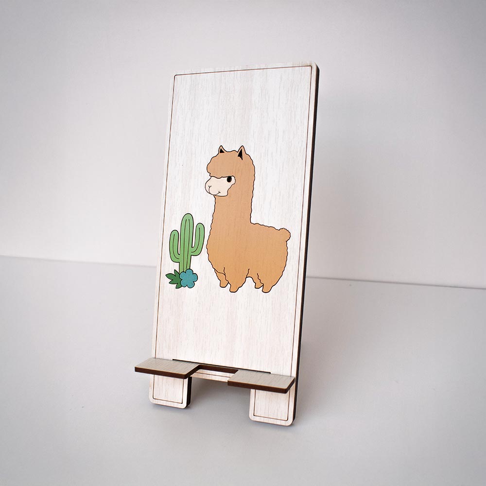 Soporte para celular en MDF con figura de Alpaca con fondo madera claro